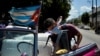 Un empleado de una compañía privada desinfecta un auto clásico en una calle de la Havana Vieja. (YAMIL LAGE/AFP)