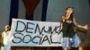 En una presentación el rapero Papá Humbertico critica los arrestos policiales y la discriminación racial en Cuba mientras exhibe el estandarte "Denuncia Social" en el Festival de Rap 2002. REUTERS/Rafael Pérez.
