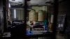 Un trabajador de una tienda o "bodega" subsidiada por el gobierno duerme por la noche encima de la barra de la tienda en La Habana, Cuba, el 18 de noviembre de 2023. (Foto AP/Ramon Espinosa)