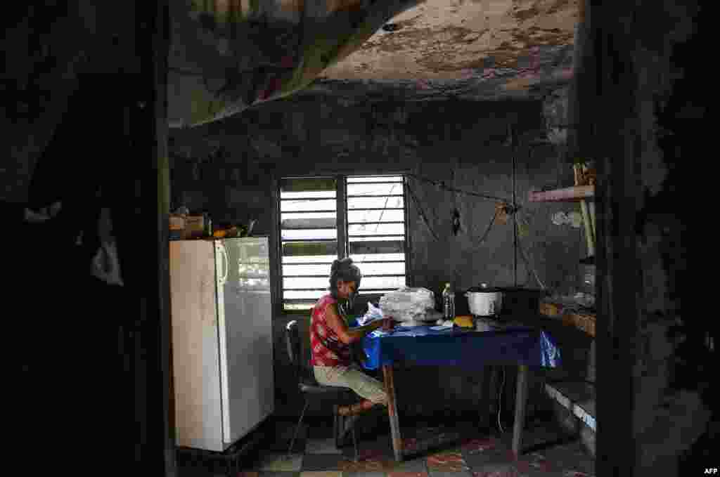 Una señora escoge arroz en su casa en El Caney, Santiago de Cuba el 21 de junio de 2017. YAMIL LAGE / AFP