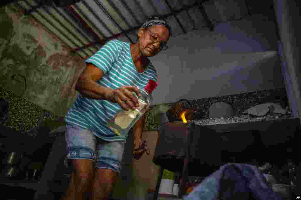 Una cubana enciende su cocina de carbón en el Mariel. 