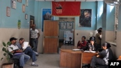 Foto Archivo. Un retrato de Fidel Castro y una bandera del Partido Comunista de Cuba en una oficina gubernamental en La Habana, Cuba.
