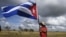 Un hombre sostiene una bandera cubana.