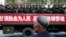 Un hombre uigur observa un camión que transporta policías paramilitares durante un mitin de juramento antiterrorista en Urumqi, Región Autónoma Uigur de Xinjiang, en 2014. (Reuters).