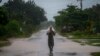 Un hombre usa un trozo de plástico como protección ante las fuertes lluvias provocadas por el huracán Helene, en Batabano, Cuba, el miércoles 25 de septiembre de 2024. (Foto AP/Ramon Espinosa)