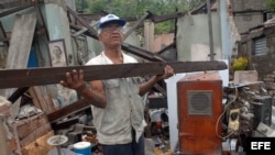 Un hombre rescata algunas pertenencias de su hogar, destruido por el paso del huracán "Sandy" en la ciudad de Santiago de Cuba,una de las zonas más castigadas por derrumbes de viviendas.