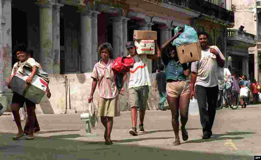 La crisis habitacional en Cuba, según cifras oficiales, requiere casi un millón de viviendas para su solución. Imagen de una familia trasladadando sus pertenencias en La Habana tras el paso de un huracán. Sus hogares corrían peligro de derrumbe. Foto: ADALBERTO ROQUE / AFP