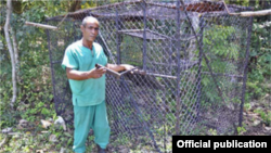Ángel Cordero (Pachi) y la jaula trampa con la que atrapó los monos verdes.