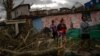 Residentes del barrio de Regla caminan sobre los escombros en busca de sus pertenencias.