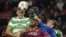 El delantero del Celtic de Glasgow Charlie Mulgrew (i) salta por el balón con los jugadores del FC Barcelona, el camerunés Alex Song (c) y el portero Pinto (d).