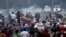 Manifestantes enfrentan los vehículos militares, cerca de la base La Carlota, en Caracas.