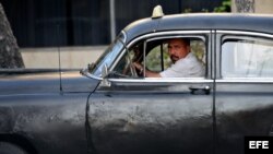 Un hombre maneja un viejo taxi particular en La Habana.
