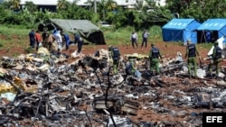 Personal cubano trabaja entre los escombros del avión accidentado en La Habana.