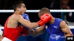 Shakhram Giyasov de Uzbekistón (rojo) y Roniel Iglesias de Cuba (azul) durante el combate de los 69kg.