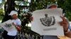 Dos personas leen el Proyecto de Constitución de la República de Cuba. (Archivo)
