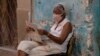 Una mujer lee el periódico en La Habana (Yamil Lage/AFP).