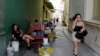 Una mujer camina mientras habla por teléfo calle de Santa Clara, provincia de Villa Clara, Cuba, el 11 de septiembre de 2023. (Foto de ADALBERTO ROQUE / AFP)