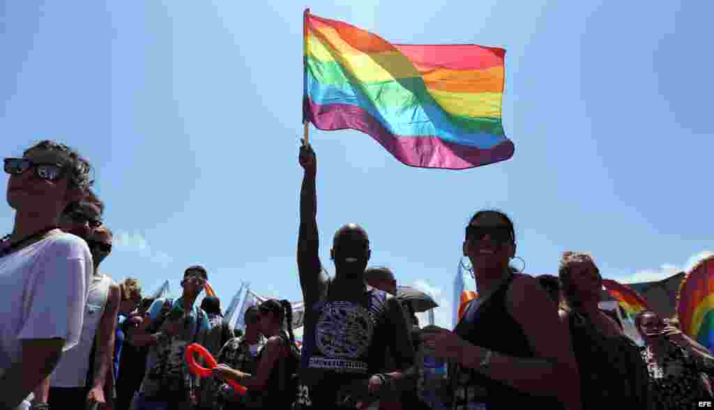 Cientos de personas con música, plumas y lentejuelas de todos los colores participan en una conga por los derechos LGTBI, en la 9 jornada contra la homofobia y la transfobia, en Cuba.