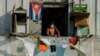 Un hombre con una máscara protectora desde su balcón en La Habana. (YAMIL LAGE / AFP)