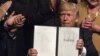 El presidente estadounidense, Donald J. Trump, muestra el memorando presidencial sobre la política con Cuba al finalizar su discurso en el teatro Manuel Artime de la Pequeña Habana, en Miami.