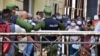 Policías controlando la población en una cola para conseguir alimentos.