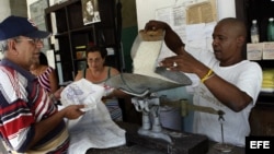 n bodeguero despacha a un anciano el arroz que se distribuye mediante la libreta de racionamiento.