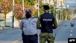 Oficiales de policía vigilan la entrada a un barrio del Vedado, en La Habana, cerrado por el coronavirus.