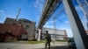 ARCHIVO - Un militar ruso vigila un área de la central nuclear de Zaporizhzhia, en el sureste de Ucrania, el 1 de mayo de 2022. La ONU adoptó una resolución donde exige a Rusia que retire urgentemente a su ejército y su personal de la central nuclear. (Foto AP/Archivo)