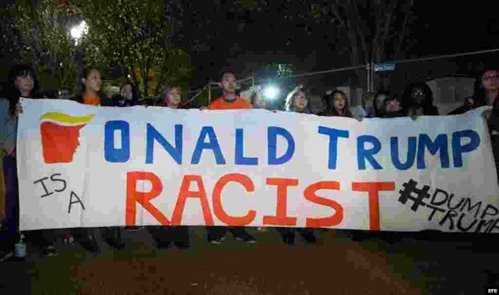 Unos  inmigrantes en Washington  sostienen una pancarta en la que se lee "Donald Trump es un racista".  