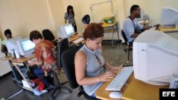 Varias personas consultan Intranet en una "sala de navegación", perteneciente a la empresa estatal Correos de Cuba.