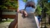 Una mujer muestra su tarjeta de vacunación tras recibir la primera dosis de Abdala contra el COVID-19. (YAMIL LAGE / AFP)