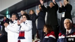 Mientras las dos Coreas desfilan unidas en los JJ.OO. de invierno, el presidente de Corea del Sur (de blanco) y la hermana de Kim Jong Un (der. atrás) aplauden, mientras el vicepresidente de EE.UU., Mike Pence (der., 1ra fila), permanece sentado.