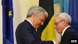 El ministro de Exteriores de Bélgica, Didier Reynders (i), condecora al hitoriador cubano Eusebio Leal (d)
