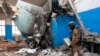 Un soldado ucraniano pasa junto a una pieza de la cola de un bombardero Su-34 ruso sobre un edificio dañado en Járkiv, Ucrania, el 8 de marzo de 2022.