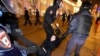 La policía rusa detiene a una manifestante en una protesta contra la invasión a Ucrania en St. Petersburg.