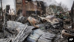 Un bombero ucraniano camina entre los restos de un avión derribado, en Kiev, Ucrania,