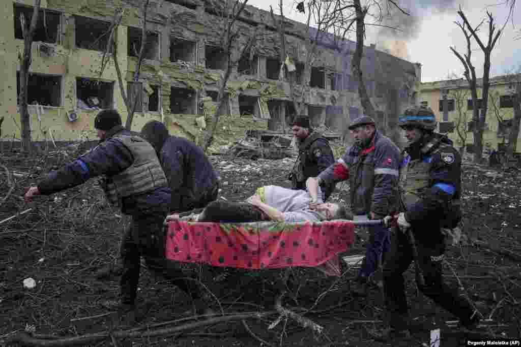 Personal de servicios de emergencia transportan en camilla a una embarazada herida por los bombardeos rusos en Mariúpol, el 9 de marzo. El bebé nació muerto y media hora después falleció la madre.