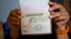 Migrante cubana muestra su pasaporte sellado con una extensión de visa costarricense