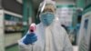 Un técnico de salud se dispone a tomarle la temperatura el jueves en Wuhan a un fotógrafo de la agencia AFP (Foto: Héctor Retamal/AFP).