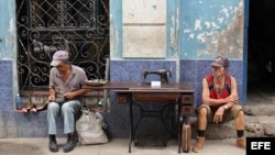 Un hombre repara zapatos, mientras otro vende una vieja máquina de coser hoy, viernes 15 de abril de 2016, en La Habana (Cuba), un día antes del inicio del VII Congreso del Partido Comunista de Cuba (PCC).