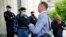 El abogado ruso Ivan Pavlov pasa junto a los agentes de policía para asistir a una sesión del tribunal después de hablar con los medios de comunicación en el Tribunal de Moscú en Moscú, Rusia, el 9 de junio de 2021. Foto: AP/Alexander Zemlianichenko.