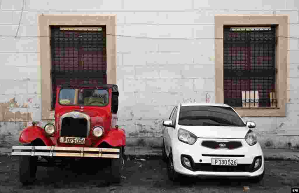 Dos vehículos uno antiguo y uno moderno permanecen estacionados en una calle de La Habana (Cuba), este viernes, 20 de enero de 2017, día en que Donald Trump asume la presidencia de EEUU.  