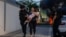 Agentes de policía israelíes evacuan a una mujer y un niño de un lugar alcanzado por un cohete disparado desde la Franja de Gaza, en Ashkelon, sur de Israel, el 7 de octubre de 2023. AP Photo/Tsafrir Abayov.