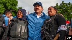 En esta fotografía del 13 de julio de 2018, la policía nicaragüense se toma una foto con el presidente Daniel Ortega, luego de semanas de disturbios en Masaya, Nicaragua. (AP / Cristóbal Venegas).