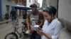 Una mujer se conecta a internet desde su celular en una calle de La Habana.
