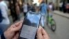 Una mujer chequea las opciones para conectarse a Internet en Cuba. SNet fue creada de manera informal, hace 15 años, para facilitar el acceso a la red. (Yamil Lage/AFP).