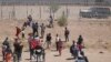 Migrantes que buscan ingresar a Estados Unidos intentan cortar una cerca de alambre de púas instalada por la Guardia Nacional de Texas en la frontera con Ciudad Juárez, estado de Chihuahua, México, el 13 de mayo de 2024. (Foto de HERIKA MARTINEZ / AFP)