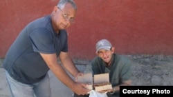El promotor del proyecto Capitán Tondique, Francisco Rangel Manzano, entrega comida a un desamparado en Colón, Matanzas.