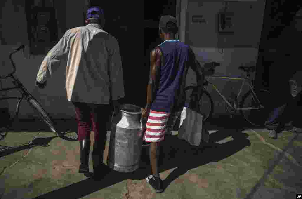 Cubanos transportan un tanque de leche en San Nicolás. El régimen dice que  le cuesta entre 1.500 y 1.600 millones de dólares mantener la canasta familiar normada, pues casi toda está sustentada sobre la importación de productos o de insumos para la producción.