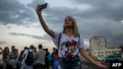 Una joven youtuber cubana graba un video en el Malecón habanero.